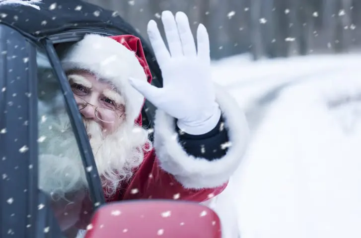 Santa waving from car in snow